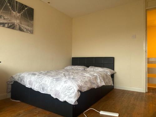 a bedroom with a bed with a black headboard at Ian house abbeywood in Abbey Wood