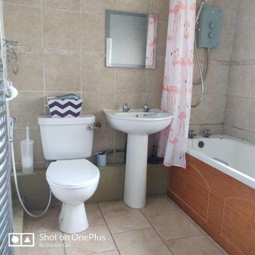 La salle de bains est pourvue de toilettes, d'un lavabo et d'une baignoire. dans l'établissement Nice 2 Bedroom house near City hospital, à Nottingham