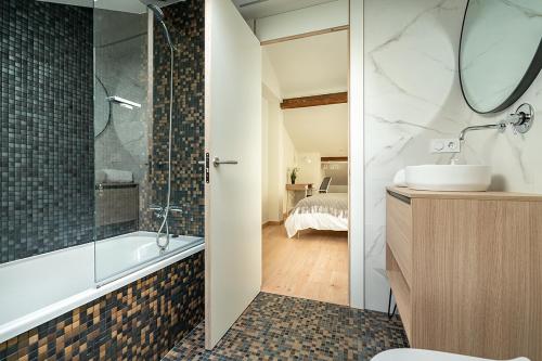 a bathroom with a tub and a sink and a shower at Alojamientos Turísticos con terraza en Santander LaPera in Santander