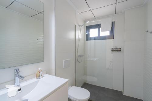 La salle de bains blanche est pourvue d'une douche et de toilettes. dans l'établissement CostaBlancaDreams Villa Strelitzia in Javea, à Benitachell