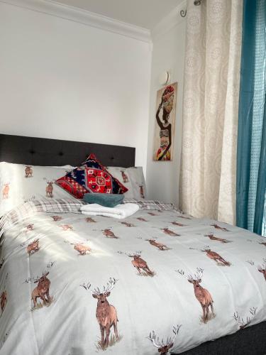 a bedroom with a bed with deer on it at Stanton - Impeccable and stylish 2 bedroom in Dagenham