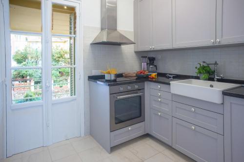 une cuisine avec des armoires blanches et un évier dans l'établissement Saint Michel - Happy Rentals, à Menton