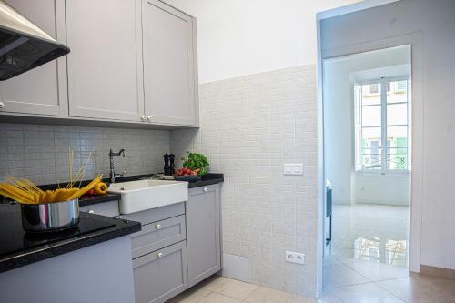 une cuisine avec des armoires blanches et un évier dans l'établissement Saint Michel - Happy Rentals, à Menton