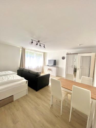 Sala de estar con cama y mesa de comedor en Komfortable Wohnung in zentraler Lage, en Ingolstadt