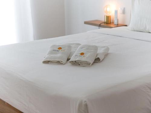 un letto bianco con due asciugamani bianchi di Panoramic E Apartment - Rooftop Pool & Sea View & BBQ ad Albufeira