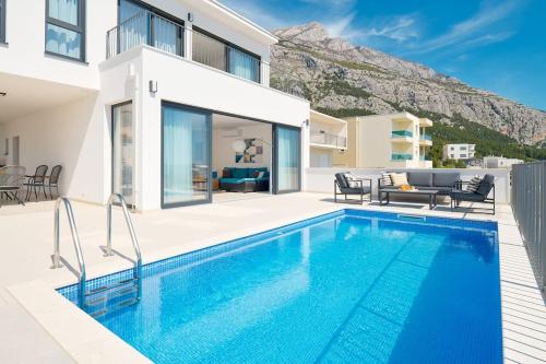 a villa with a swimming pool in front of a house at Ferienhaus Komplex - Villa David - Makarska Exklusiv in Veliko Brdo