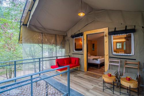 d'un salon avec un canapé rouge et un balcon. dans l'établissement Everest Base Camp, Near George Everest House, 5kms from Library chowk, à Mussoorie