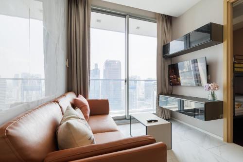 een woonkamer met een bank en een groot raam bij Modern Luxury 2 Bedrooms at BTS Nana on 30 Floor in Bangkok