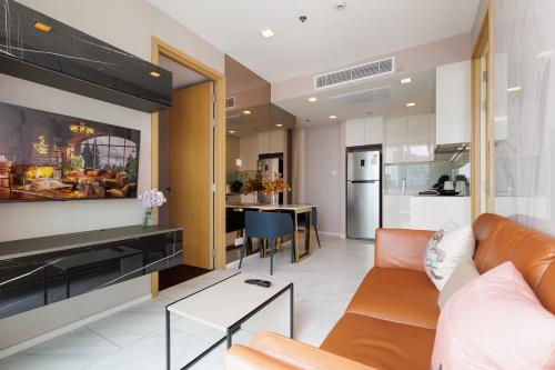 een woonkamer met een bank en een keuken bij Modern Luxury 2 Bedrooms at BTS Nana on 30 Floor in Bangkok