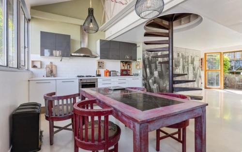 une cuisine avec une table en bois et des chaises rouges dans l'établissement Superbe loft aux portes de paris, à Ivry-sur-Seine
