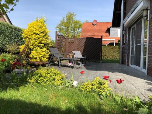 eine Terrasse mit einem Tisch, Stühlen und Blumen in der Unterkunft Haus Seetreppe in Göhren-Lebbin