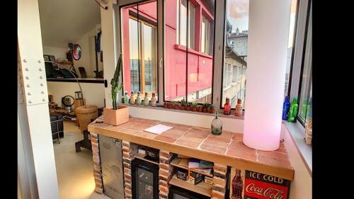 une pièce avec une fenêtre et un comptoir avec des livres dans l'établissement Superbe loft aux portes de paris, à Ivry-sur-Seine