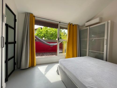 - une chambre avec un lit et une fenêtre avec un hamac dans l'établissement Superbe loft aux portes de paris, à Ivry-sur-Seine