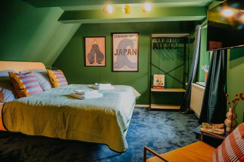a green bedroom with a bed and a green wall at sleepArt green in Celle
