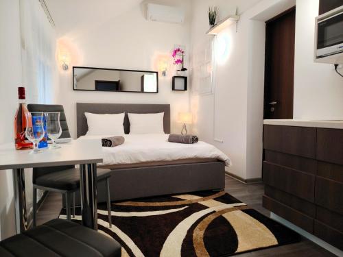 a bedroom with a bed and a table and a mirror at Nyuszis Apartman in Kiskunmajsa