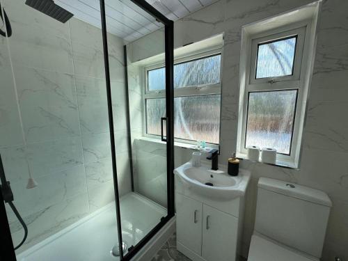a bathroom with a shower and a sink and a toilet at Stunning 4 BED House for Contractors & Holiday Makers in Reading