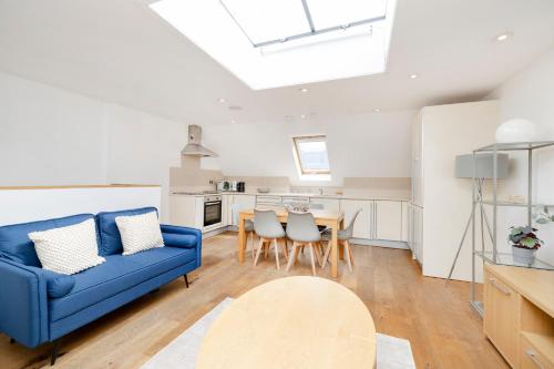 a living room with a blue couch and a table at JOIVY Superb Flats in the Heart of Edinburgh in Edinburgh