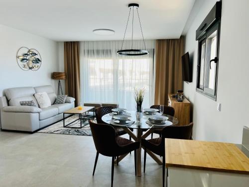 comedor y sala de estar con mesa y sillas en Super con gran terraza y vistas, en Gran Alacant
