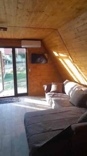 a large bed in a room with a wooden ceiling at Wild A-frame in Baile Felix