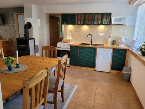 a kitchen with a wooden table and a kitchen with green cabinets at Ferienwohnung 500m zum See - a55874 in Vollrathsruhe