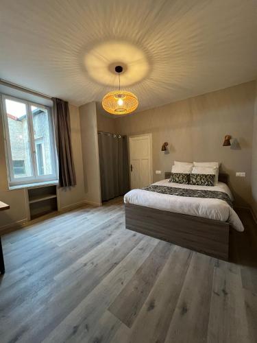 une chambre avec un grand lit et un lustre dans l'établissement LE 139 carcassonne, à Carcassonne