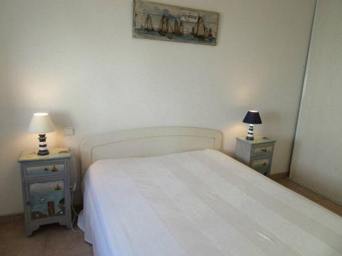 - une chambre avec un lit blanc et 2 tables de chevet dans l'établissement La maison bleue de Sion, à Saint-Hilaire-de-Riez