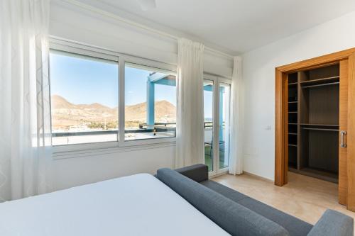 a bedroom with a bed and a large window at CT 297 AL - Faro's Villa Las Arenas - San José in Níjar