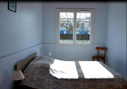 Schlafzimmer mit einem Bett und einem Fenster in der Unterkunft La boisée de la Conge in Saint-Hilaire-de-Riez
