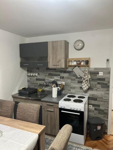 a kitchen with a stove and a counter top at Apartmani Doksas Degurić in Belić