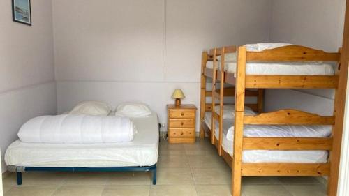 une chambre avec deux lits superposés et une lampe dans l'établissement Au Pibolon des bois, à Saint-Hilaire-de-Riez