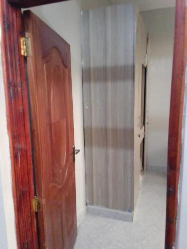 - une porte en bois dans une chambre avec couloir dans l'établissement Peace Haven, à Kamondo