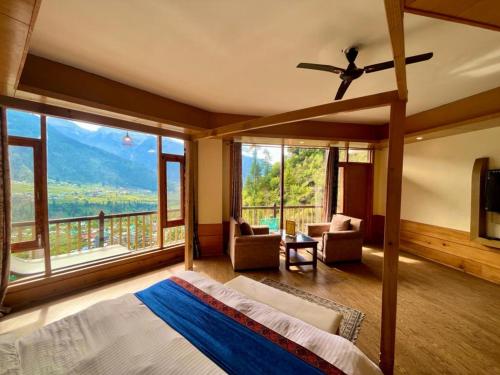 1 dormitorio con cama y ventana grande en Goroomgo Hotel BD Resort Manali - Excellent Stay with Family, Parking Facilities en Manāli