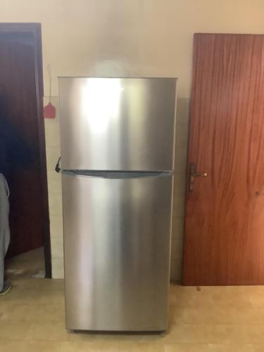 a stainless steel refrigerator in a kitchen with a door at Kallipateira apartments in Rhodes Town
