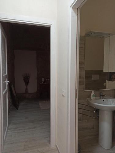 a bathroom with a sink and a toilet and a mirror at Piazza San Giorgio in Dolianova