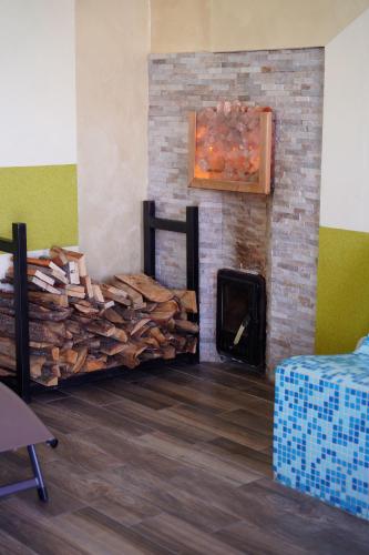 a room with a fireplace with a pile of wood at Siedlisko Staszkówka in Huszlew