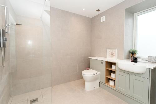 a bathroom with a shower and a toilet and a sink at Disdow House; luxury 5 bedroom house with views in Gatehouse of Fleet