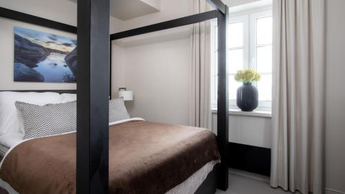 a bedroom with a canopy bed and a window at Wilhelmsen House in Tønsberg
