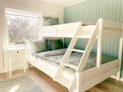 a white bunk bed in a room with a window at 3 BR home for 9 guests in a quiet neighborhood in Tórshavn
