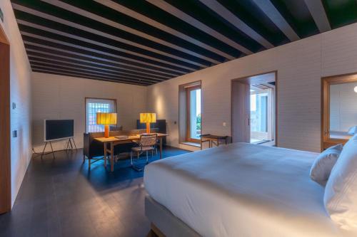 a bedroom with a large bed and a table with chairs at Atrio in Cáceres