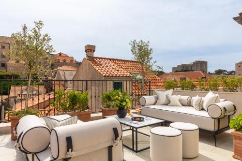 d'une terrasse avec un canapé et des chaises sur un balcon. dans l'établissement Boutique Hotel Stari Grad, à Dubrovnik