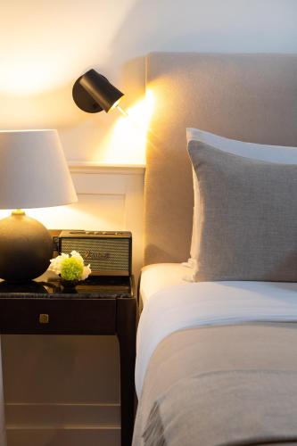 a bedroom with a bed and a lamp on a night stand at Boutique Hotel Stari Grad in Dubrovnik