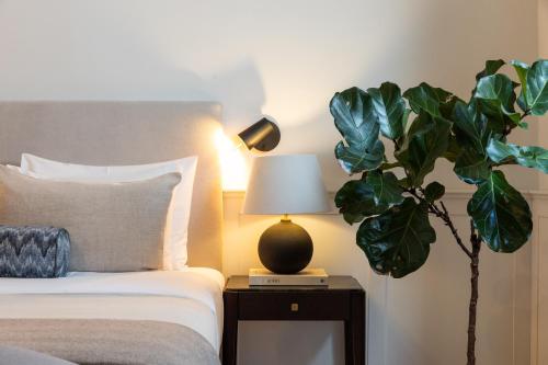 a bedroom with a bed with a lamp and a plant at Boutique Hotel Stari Grad in Dubrovnik