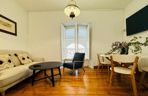 een woonkamer met een bank en een tafel bij La Casa de María Pita in A Coruña