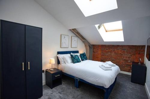 a bedroom with a bed and a brick wall at The Garnet Suite in Manchester