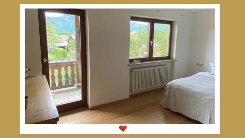 um quarto com uma cama e uma janela aberta em Berghupferl-Alm - do legst di nieda em Flintsbach am Inn