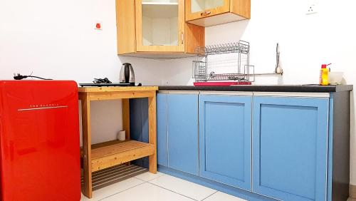 uma cozinha com armários azuis e um frigorífico vermelho em Mansion One - Large Studio with 1 bathroom em George Town