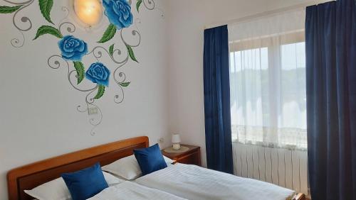 a bedroom with a bed and a wall with blue roses at Apartments Villa Ksenija in Umag