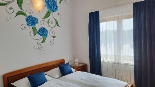 a bedroom with a bed and a wall with blue roses at Villa "Pied-à-terre" Residence & Spa in Umag