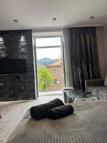 a living room with a couch and a large window at Стильная студия у Айрин с панорамным видом на гору ,,Арчук" in Vanadzor