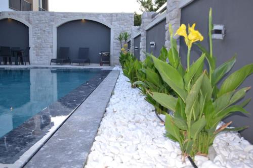 ein Schwimmbad mit Pflanzen neben einem Haus in der Unterkunft çeşme boyalıkta süper lüks in Cesme
